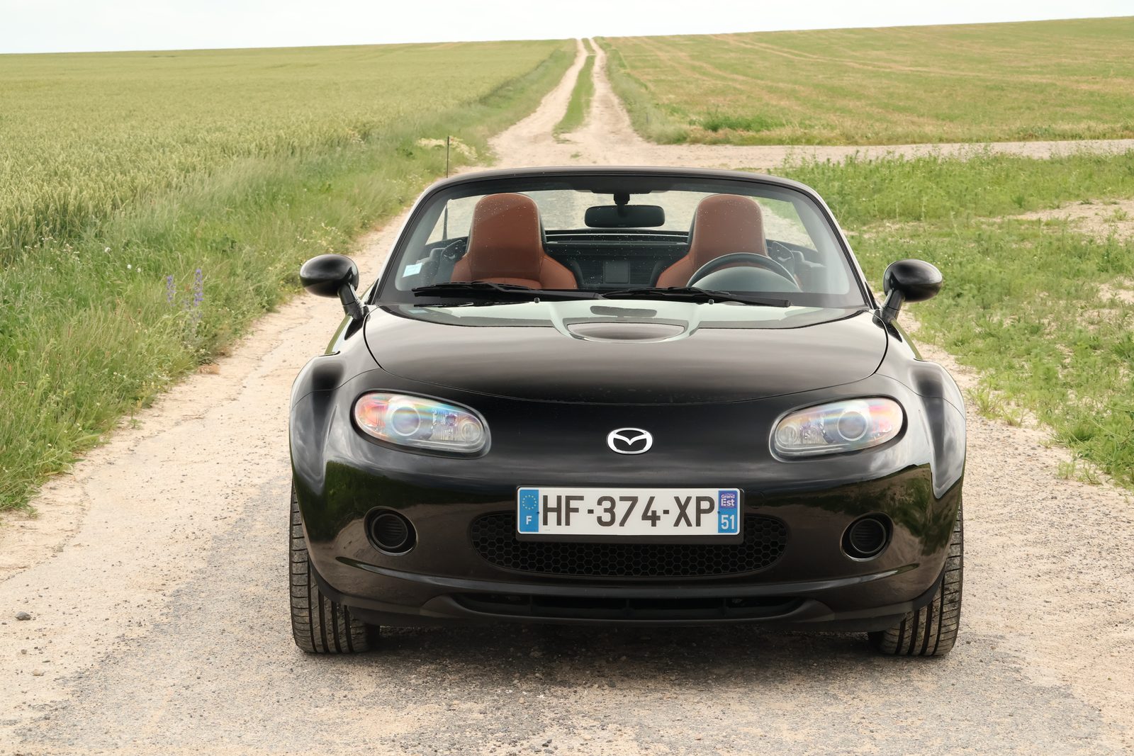 Mazda MX-5 NC noire de face, toit ouvert